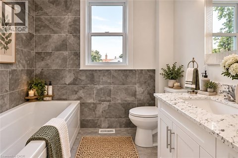 A bathroom with a tub, toilet, and sink.