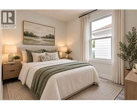 A bedroom with a large bed, two lamps, and a painting on the wall.