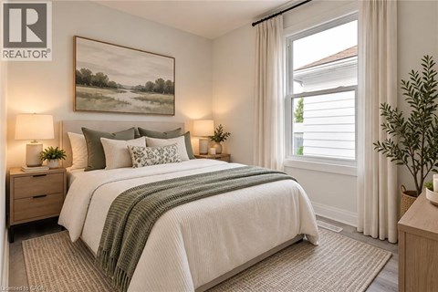 A bedroom with a large bed, two lamps, and a painting on the wall.