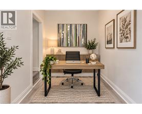 A well-lit office space with a desk, chair, and potted plants.