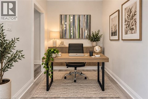 A well-lit office space with a desk, chair, and potted plants.