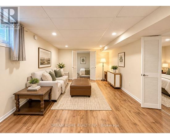 A well-lit living room with a white sofa, wooden coffee table, and a rug on the floor.