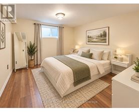 A bedroom with a large bed and a painting on the wall.