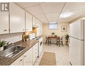 A kitchen with white cabinets and a refrigerator.