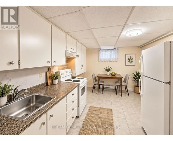 A kitchen with white cabinets and a refrigerator.