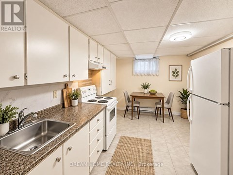 A kitchen with white cabinets and a refrigerator.