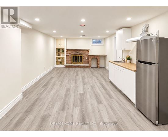 A kitchen with a refrigerator on the right side.