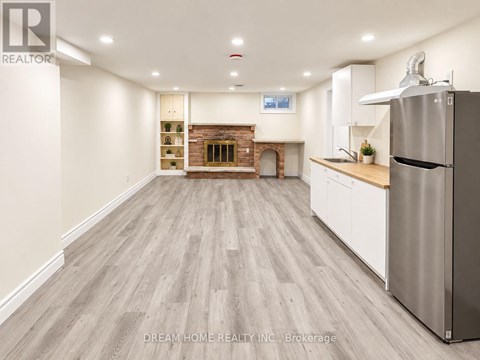 A kitchen with a refrigerator on the right side.