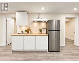 A modern kitchen with white cabinets and a stainless steel refrigerator.