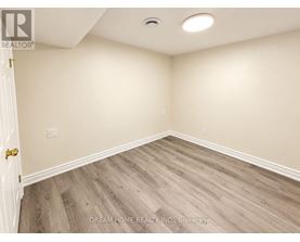 A room with wooden flooring and a white door.