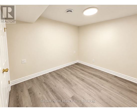 A room with wooden flooring and a white door.