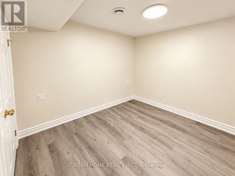 A room with wooden flooring and a white door.