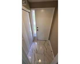 A hallway with marble flooring and white doors.