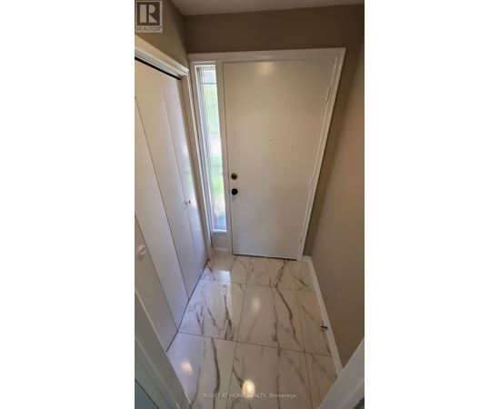 A hallway with marble flooring and white doors.