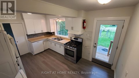 A kitchen with white cabinets and a black stove top oven.