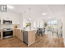 A modern kitchen with wooden floors and stainless steel appliances.