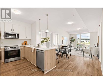 A modern kitchen with wooden floors and stainless steel appliances.