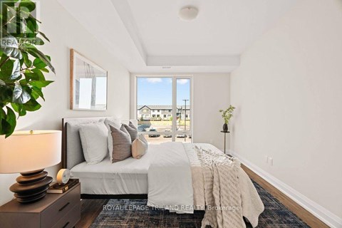 A bedroom with a large bed and a view of the outside through a window.