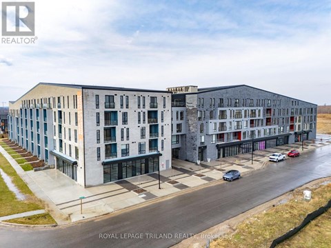 A building complex with cars parked in front.