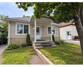 A house with a front porch and a tree in front.