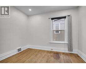 A room with a window and a radiator on the floor.