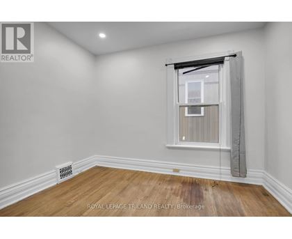 A room with a window and a radiator on the floor.