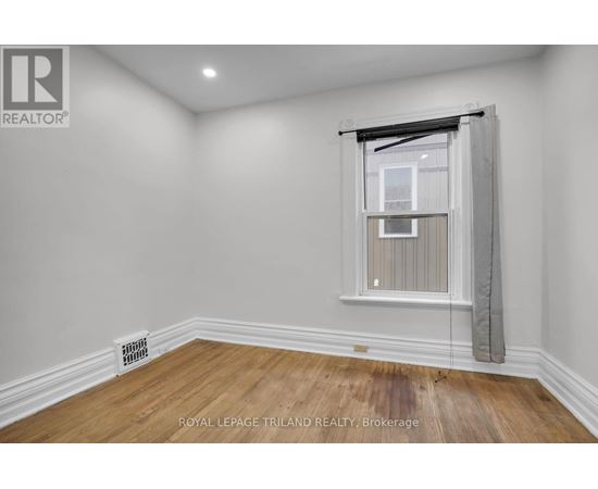 A room with a window and a radiator on the floor.