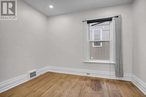 A room with a window and a radiator on the floor.