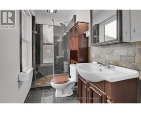 A bathroom with a toilet, sink, and mirror.