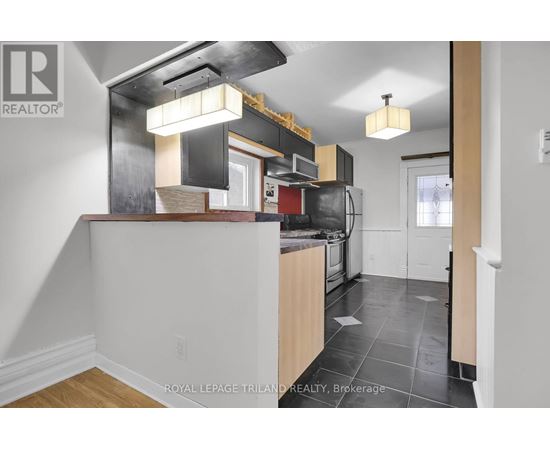 A kitchen with a white counter top and a black stove top oven.