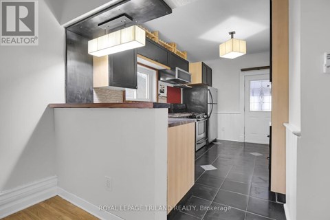 A kitchen with a white counter top and a black stove top oven.