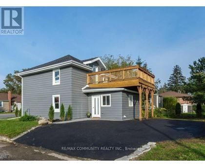 A house with a grey exterior and a wooden deck.