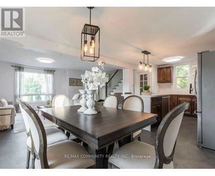 A dining room with a table set for four and a chandelier hanging from the ceiling.