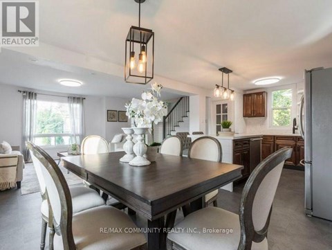 A dining room with a table set for four and a chandelier hanging from the ceiling.