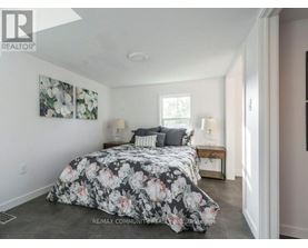 A bedroom with a floral bedspread and two lamps on a table.