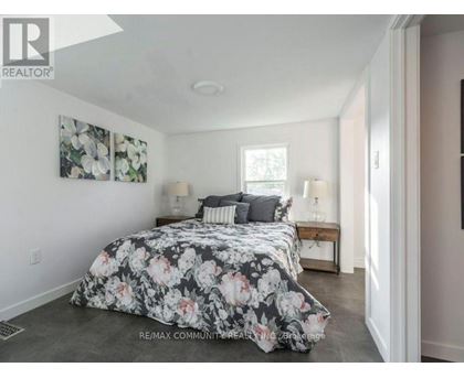 A bedroom with a floral bedspread and two lamps on a table.
