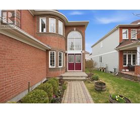 A house with a red brick exterior and a red door is for sale.