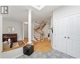 A spacious room with a staircase and a white door.