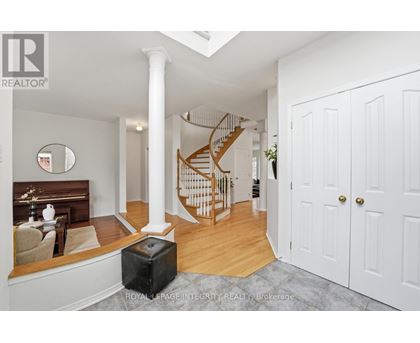 A spacious room with a staircase and a white door.