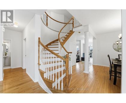 A wooden staircase with white railings leads to the upper floor of a home.
