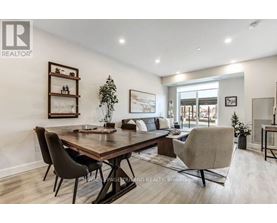 A well-lit dining room with a wooden table and chairs.