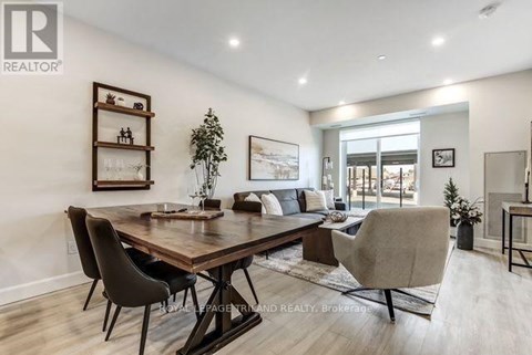 A well-lit dining room with a wooden table and chairs.