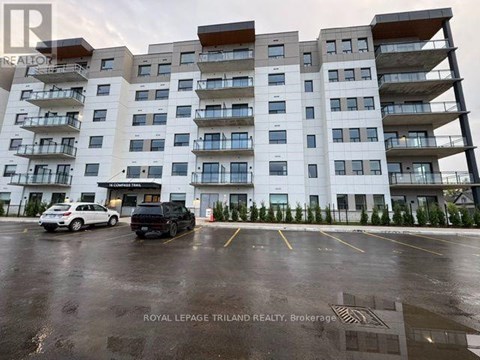 A white and brown building with a parking lot in front.
