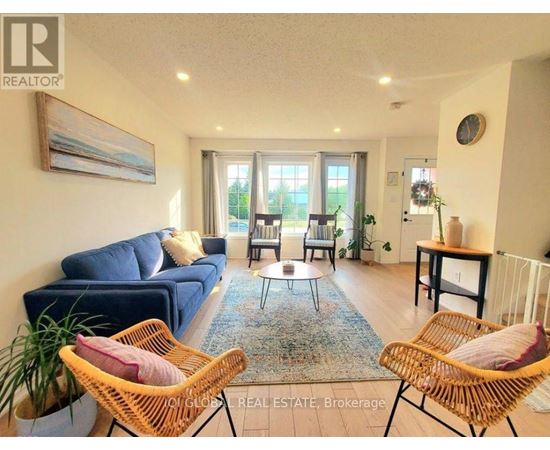 A living room with a blue couch and two wicker chairs.