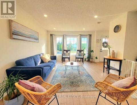 A living room with a blue couch and two wicker chairs.