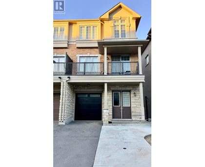 A two-story building with a balcony and a garage door.