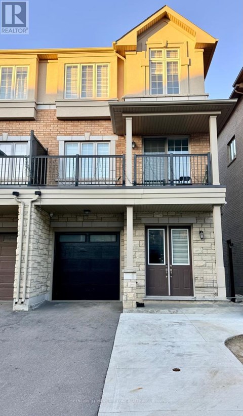 A two-story building with a balcony and a garage door.