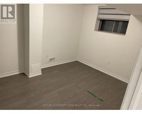 A room with a window and a wooden floor.