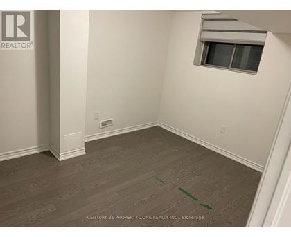 A room with a window and a wooden floor.