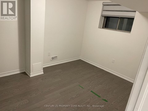 A room with a window and a wooden floor.